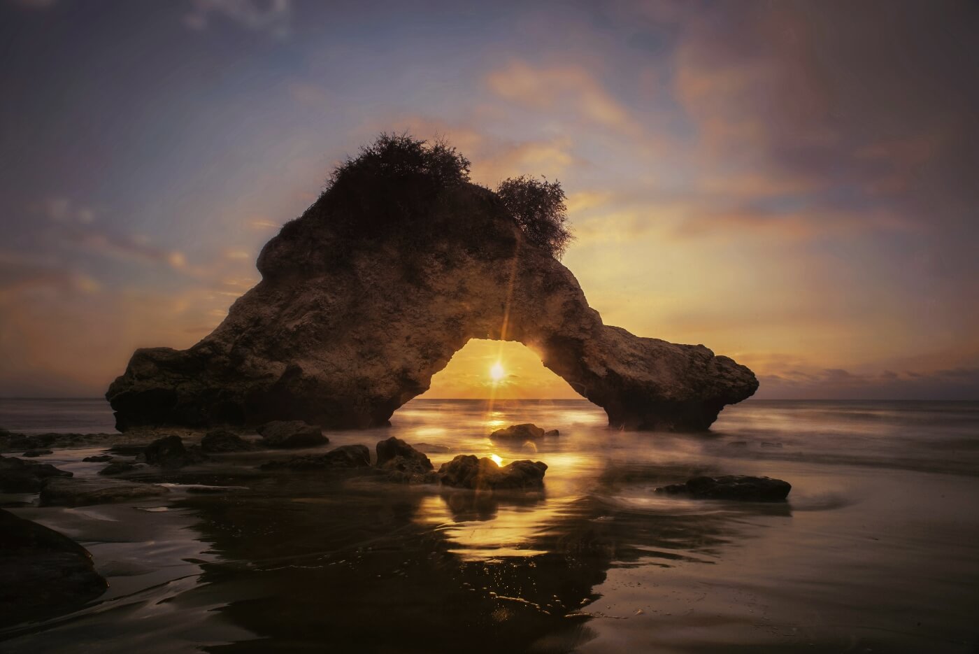 Spectacular pink and orange sunset over Pacific Ocean beach in Ecuador with silhouettes of people