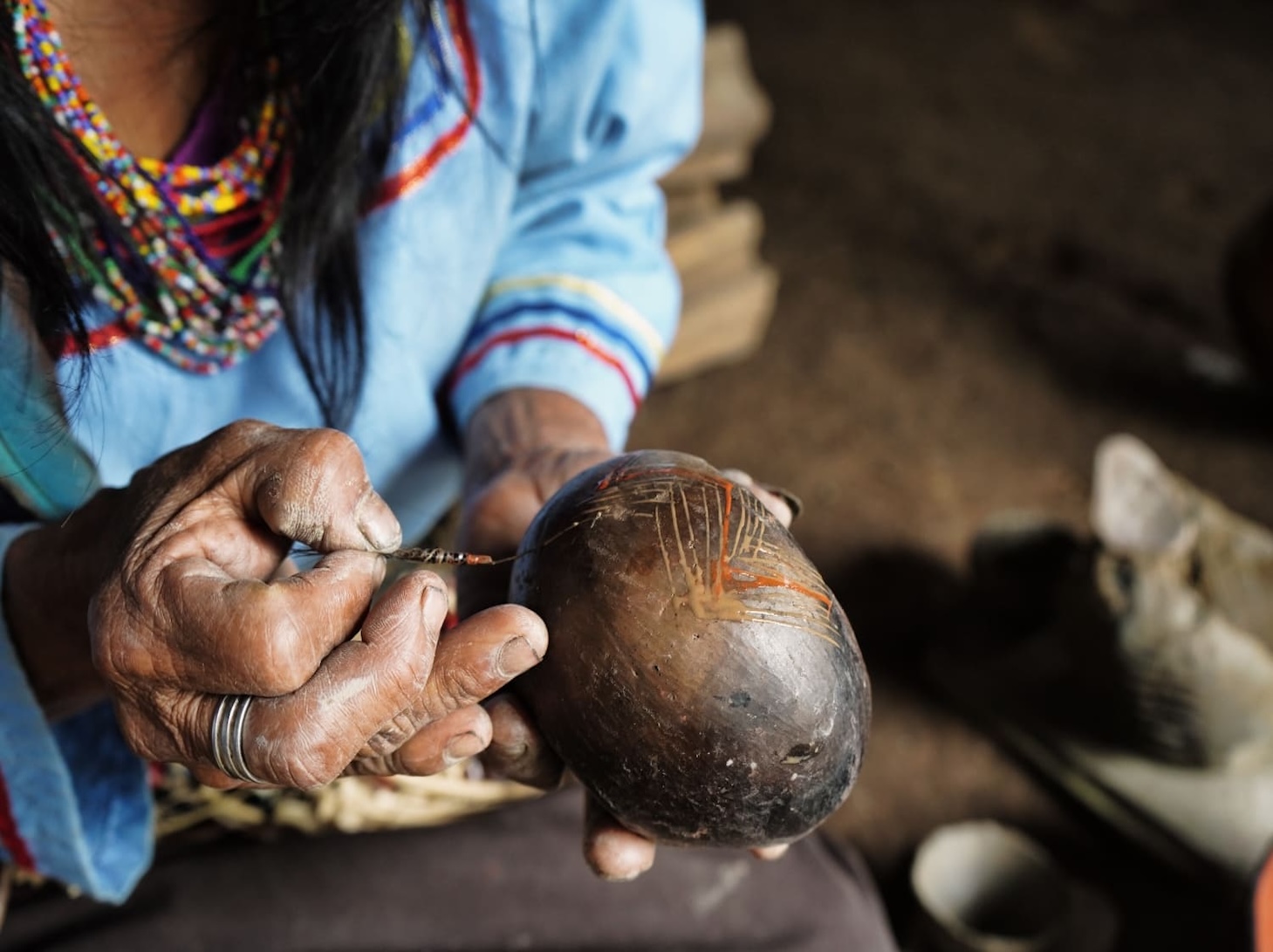 Indigenous artisan carving detailed design on tagua nut in Ecuador